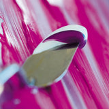 Close-up of a paint knife with pink paint on a pink background