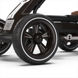 Close-up of a black and white wheel on a stroller with 'EXIT TOYS' branding.