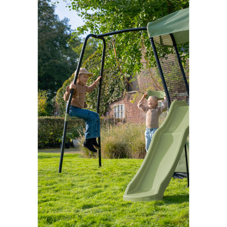 Children playing on a swing set with a slide in a garden.