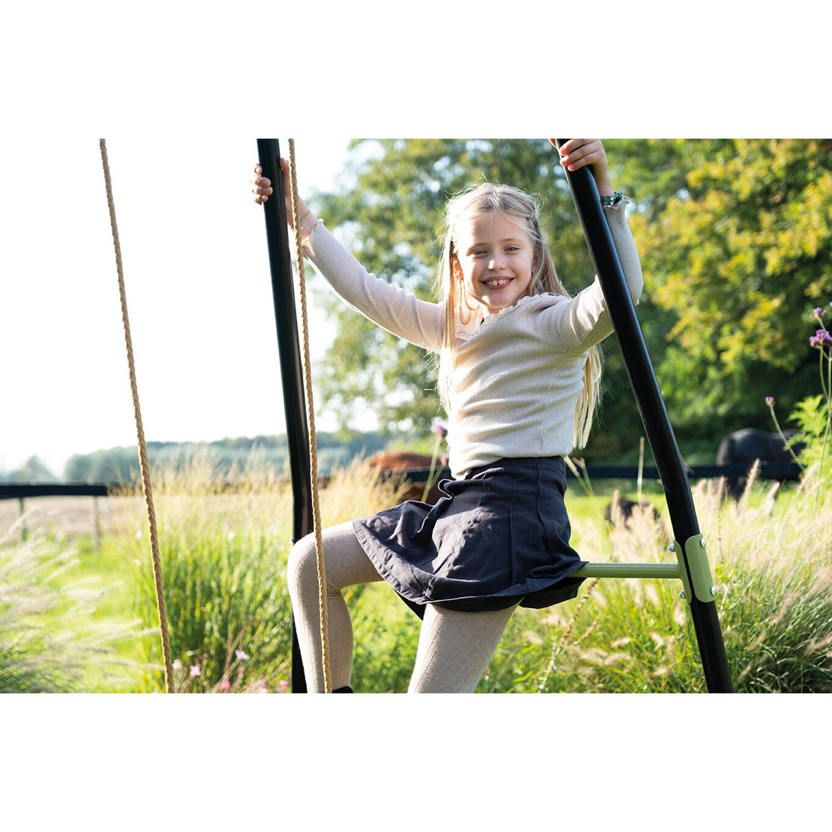 Child on a swing in a park with greenery and sunlight