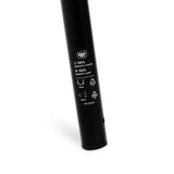 Black cylindrical object with recycling symbols and text on a white background