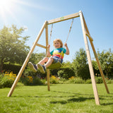 Child swinging on a wooden swing set in a garden with trees and flowers in the background.