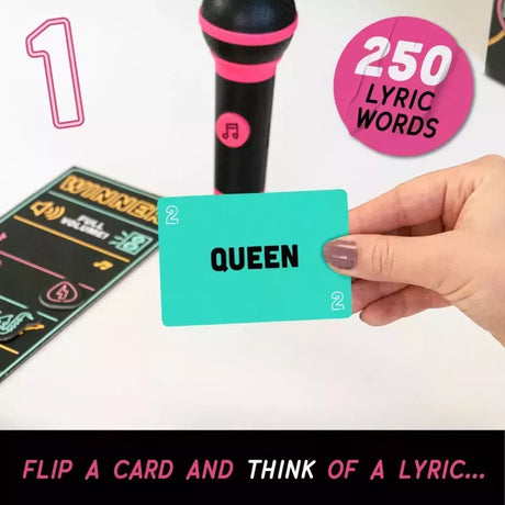 A hand holds a turquoise card labeled 'QUEEN' in front of a black and pink microphone and a lyric card. Pink text badges read '1', '250 LYRIC WORDS', and 'FLIP A CARD AND THINK OF A LYRIC.