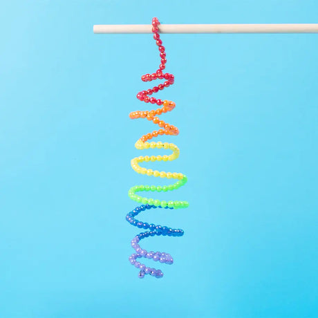 Colorful beaded spiral on a stick against a blue background