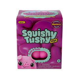 A box of Squishy Tushy Toys, Series 1, featuring a pink pig illustration and a clear window showing two pink squishy eggs inside, on a white background.