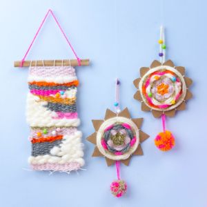 Three macrame colourful woven wall hangings on a light blue background