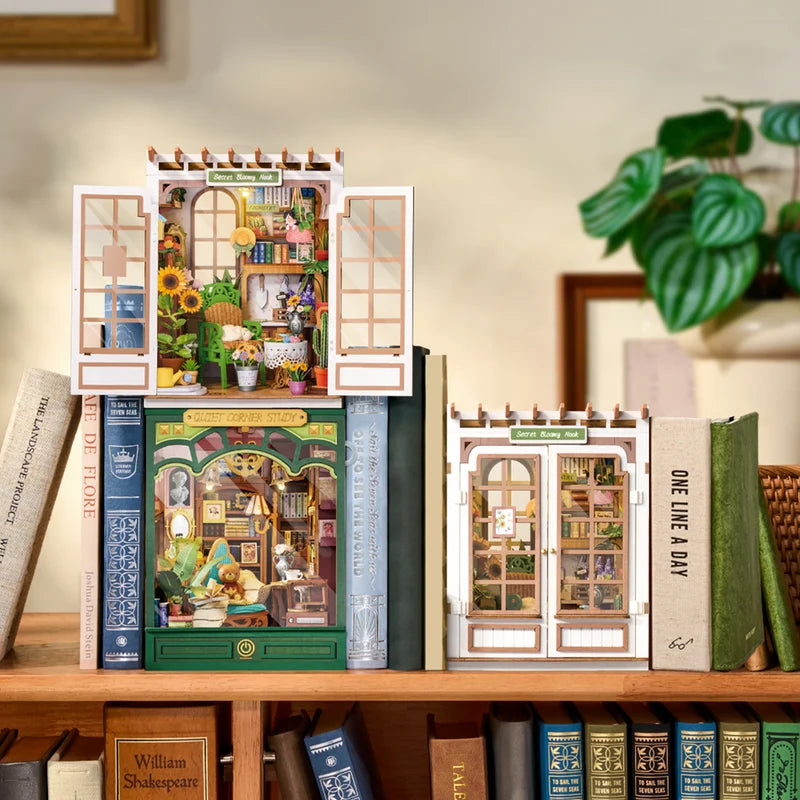 Decorative bookends shaped like miniature houses on a shelf with books and a plant.